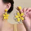 Detailed macro view of yellow woven flower earrings with elegant gold-tone petal frames - 5# Silver Post Style