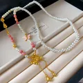 Dettaglio della collana lunga di perle artificiali con loto e farfalla retrò - Stile Lungo con Nappa di Loto / Bianco Oro Rosa