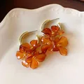 Detail showing the intricate marbled texture of French retro amber acrylic flower earrings. - Silver Post-Tie-Dye Flower / Gold-Orange
