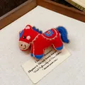 Close-up of a handmade red embroidered fabric horse brooch with blue floral details - Ethnic Embroidered Horse