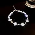 Detailed shot of pearl and sparkling zircon four-leaf clover bracelet on dark surface - Pearl Clover Style (5273621715167) / Silver