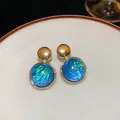 Macro view of blue iridescent round stud earrings with elegant gold metallic accents - Irregular Round (25)