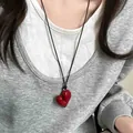 Dettaglio del ciondolo a cuore rosso irregolare su un cordino nero regolabile lungo - Rosso