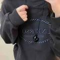 Primo piano di una collana con ciondolo a cuore nero irregolare su cordino in pelle - Nero