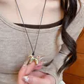 Minimalistische gouden paardenhanger ketting met zwart koord getoond op een model - Zwart Touw Paard Stijl (15#)