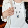 Minimalistische zilveren paardenhanger ketting met blauwe kraal gedragen door een model - Kwastje Accent Paard Stijl (14#)