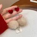 Close-up of red velvet heart and beige fur ball earrings held in hand. - Style 6 Pendant (Silver Post) / Red/Beige