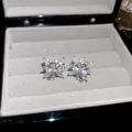 Elegante silberne Blumen-Ohrstecker mit funkelnden Kristallen in einer grauen Schmuckschachtel - Silberner Ohrclip (54#)