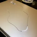 Élégant collier de couleur argent avec sept petites perles sur un support doré mat - Style 7 Perles en Rang (HN1976)