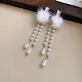 Close-up detail of elegant white faux fur ball earrings with dangling pearl bead chains. - 39# Silver Post Style / Silver/White