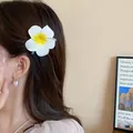 Close-up of elegant white frangipani flower hair clip worn by model for summer hair styling - 1# Duckbill Clip - Large Plumeria / White-Yellow