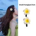 Detailed view of 4cm small frangipani flower hair clips worn by model and in close-up - 3# Duckbill Clip - Small Plumeria / White-Yellow