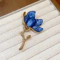 Macro view of blue enamel flower brooch with gold-toned stem in a jewelry box - Gold-Blue