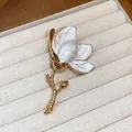 Detailed close-up of elegant white enamel flower brooch with premium gold plating texture - Gold-White