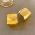 Dettaglio di orecchini a cerchio a forma di C larghi in oro con finitura a specchio - Oro
