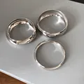 Top view of three minimalist polished silver metal bangles with different band widths - Three-Piece Set / Silver