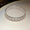Vista dettagliata del bracciale a tre strati avvolgente con perle e strass luccicanti. - Argento