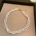 Elegant multi-layer twisted white pearl necklace displayed on a beige jewelry tray - Necklace-White
