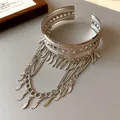Primo piano del bracciale da braccio con nappe a foglia e motivi traforati chic - Argento