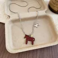 Vue détaillée d'un collier avec pendentif cheval en émail rouge et breloque étoile dorée - Argent-Rouge