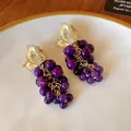 Dettaglio di orecchini vintage a grappolo d'uva con pietre viola. - Orecchini a clip / Viola/Oro