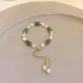 Detail view of pearl bracelet with green cylindrical stones and adjustable gold chain - Bamboo Style / Green