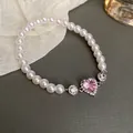 Elegant white pearl bracelet featuring a brilliant pink heart-shaped gemstone centerpiece - Heart Style / White