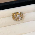 Close-up of gold multilayer ring featuring elegant teardrop zircons and white pearls. - Gold