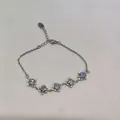 Elegant silver-toned link bracelet featuring zircon-encrusted diamond flower charms - Silver