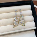 Detailansicht unregelmäßiger geometrischer Glashänger mit funkelnden Kristallen - Unregelmäßige Geometrische Ohrringe / Gold-Weiß