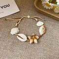 Close-up of handmade shell and starfish bracelet on textured fabric background - Bracelet / White Starfish