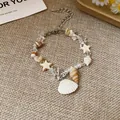 Macro view of vacation style bracelet with natural stones, stars, and shell charms. - Bracelet / White-Shell-Star