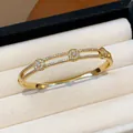 Gros plan détaillé d'un jonc à fleurs en zircon plaqué or 18 carats dans un écrin - Style 10 (Or)