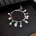 Silver bracelet with seashell charms and blue iridescent beads in black tray - Bracelet / Silver Style 21