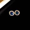 Dettaglio di eleganti orecchini a perno tondi con cristallo blu e alone di diamanti bianchi. - Stud orecchini / Perno in argento-Blu