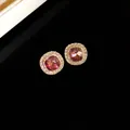 Vista dettagliata di eleganti orecchini a lobo dorati con gemma rosa e halo di cristalli - Stud orecchini / Silver Earring Post - Viola