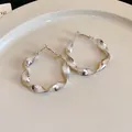 Detailed close-up view of silver twisted spiral hoop earrings with elegant texture - Silver