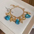 Elegant resort style charm bracelet with golden shells blue stones and white pearls - Bracelet / Gold Blue Style 16