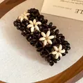 Close-up of multi-layer wooden bead bracelet with dark and cream floral patterns and design - Flower Style / Coffee & White