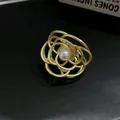 Primo piano di una molletta per capelli a fiore dorato vintage con perla centrale - Piccolo / Oro