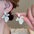 Close-up of white flower-shaped stud earrings with a central blue gemstone detail - 9# Gem Flower Style