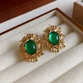Detail view of vintage gold leaf earrings with oval green stones in a jewelry box - Vintage Oval Leaf Style (HE12269-WE002) / Gold (Green Main Stone)