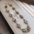 Elegant vintage gold-toned necklace with oval grey iridescent stones in ornate frames - Necklace / Gold-Grey