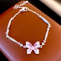 Elegant vintage butterfly bracelet with pink gemstones and shimmering crystals on a brown base. - Butterfly Bracelet / Pink