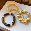 Detail of gold ball bead bracelet and brown acrylic pearl bangle set on a wooden tray - 3-Piece Bracelet Set / Gold Brown