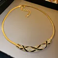 Close-up of a gold-toned snake chain necklace with rhinestone and black enamel accents - Necklace (3) / Gold