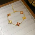 Close-up of a luxury 18K gold plated bracelet featuring red and gold clover motifs. - 30# Bracelet - Gold and Red