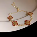 Detailed view of an 18K gold plated zircon bracelet featuring red clover motifs and adjustable slider - 28# Bracelet - Gold - Red