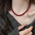Close-up of deep red bead necklace worn over a grey V-neck sweater, autumn jewelry style - Diameter 8mm / Silver Chain with Red Beads