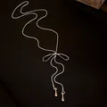 Macro detail of elegant silver bowknot tassel necklace with adjustable slider chain - Bowknot Tassel Drawstring Style / Silver